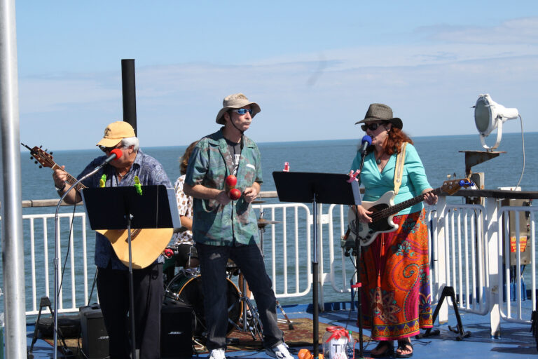 Performers sing at the Sunday Jamz event- featuring mics, guitars, and maracas