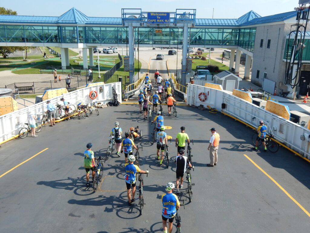 Bicyclists walk off of the car deck, entering Cape May