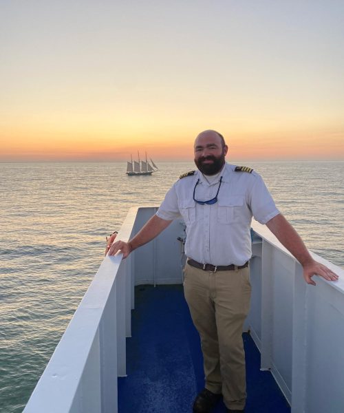 Captain Bowen standing in front of a sunset