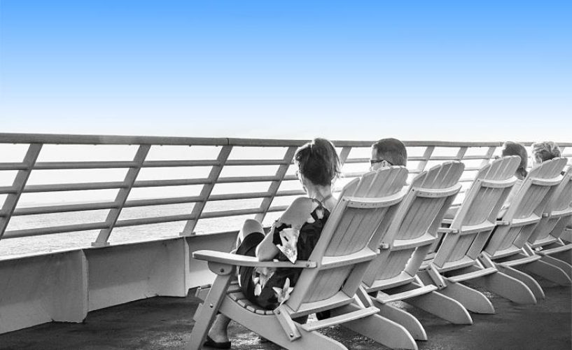 Passengers lounge in the Adirondack chairs aboard the top deck